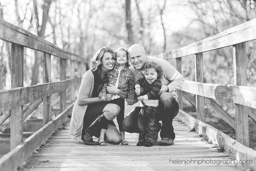 Black and white image of happy family on a bridge in Potomac, MD
