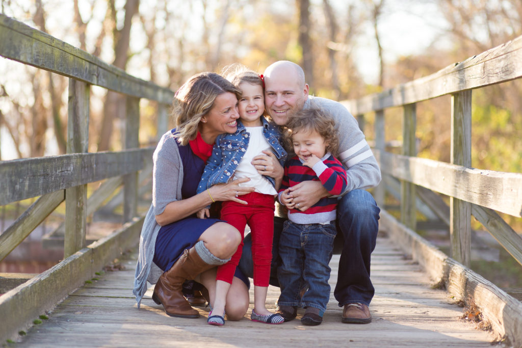 family of four laughing together in the autumn