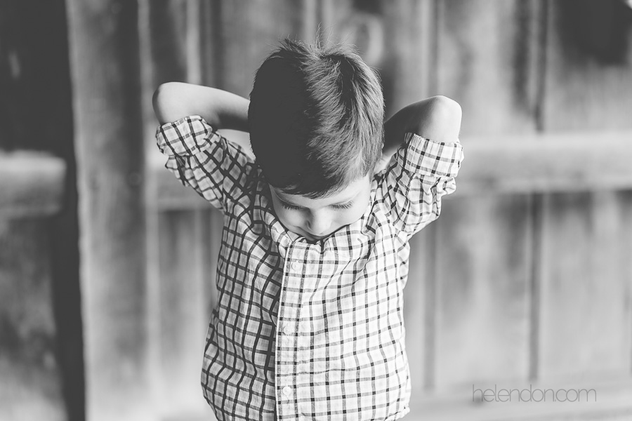 black and white photo of boy with hands behind head