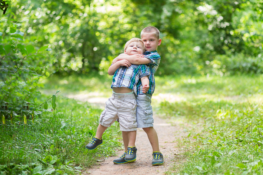 big brother squeezing baby brother