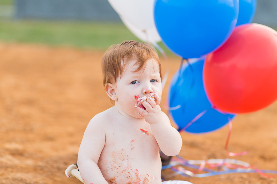 messy baby boy eating cake