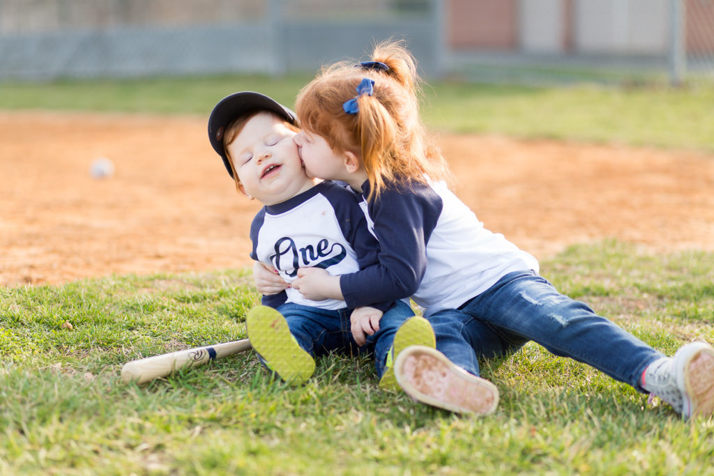 big sister kissing baby brother on cheek