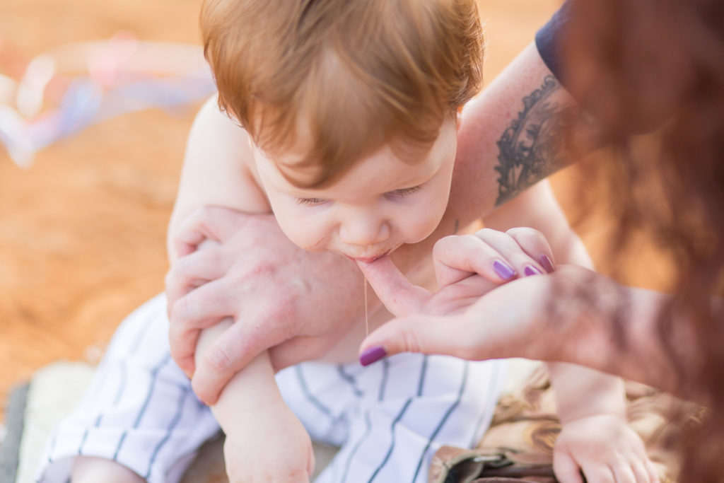 mom feeding baby frosting on finger