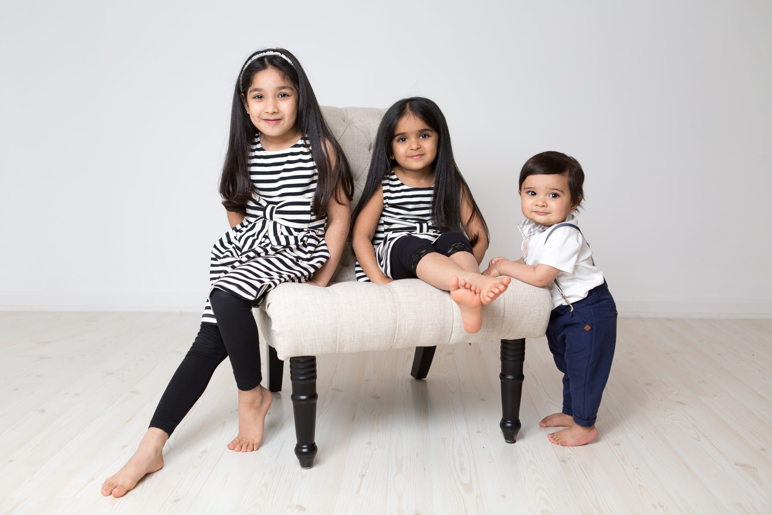 three children sitting on chair together