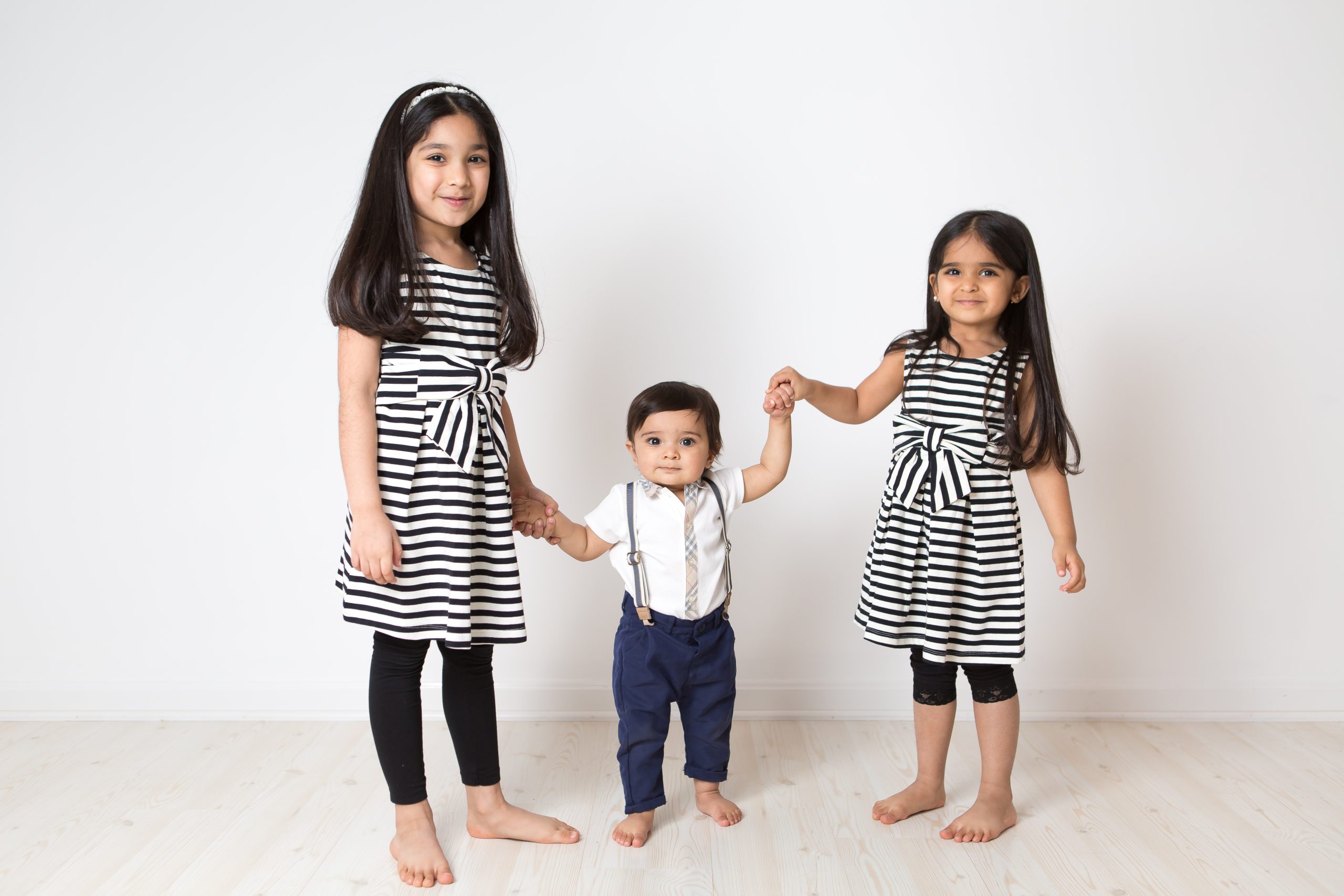 three kids holding hands in studio