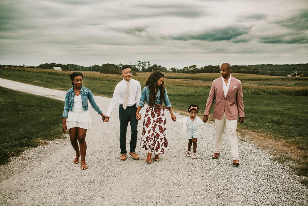 family of five holding hands walking