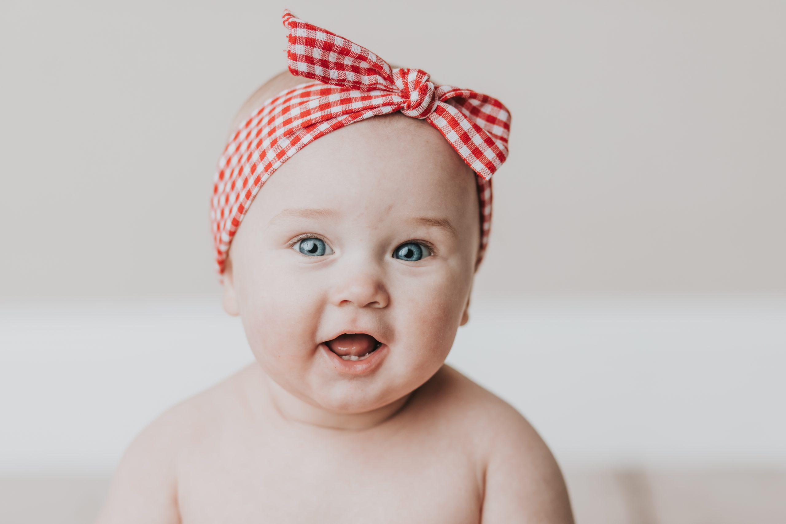 close up of baby smiling with headband