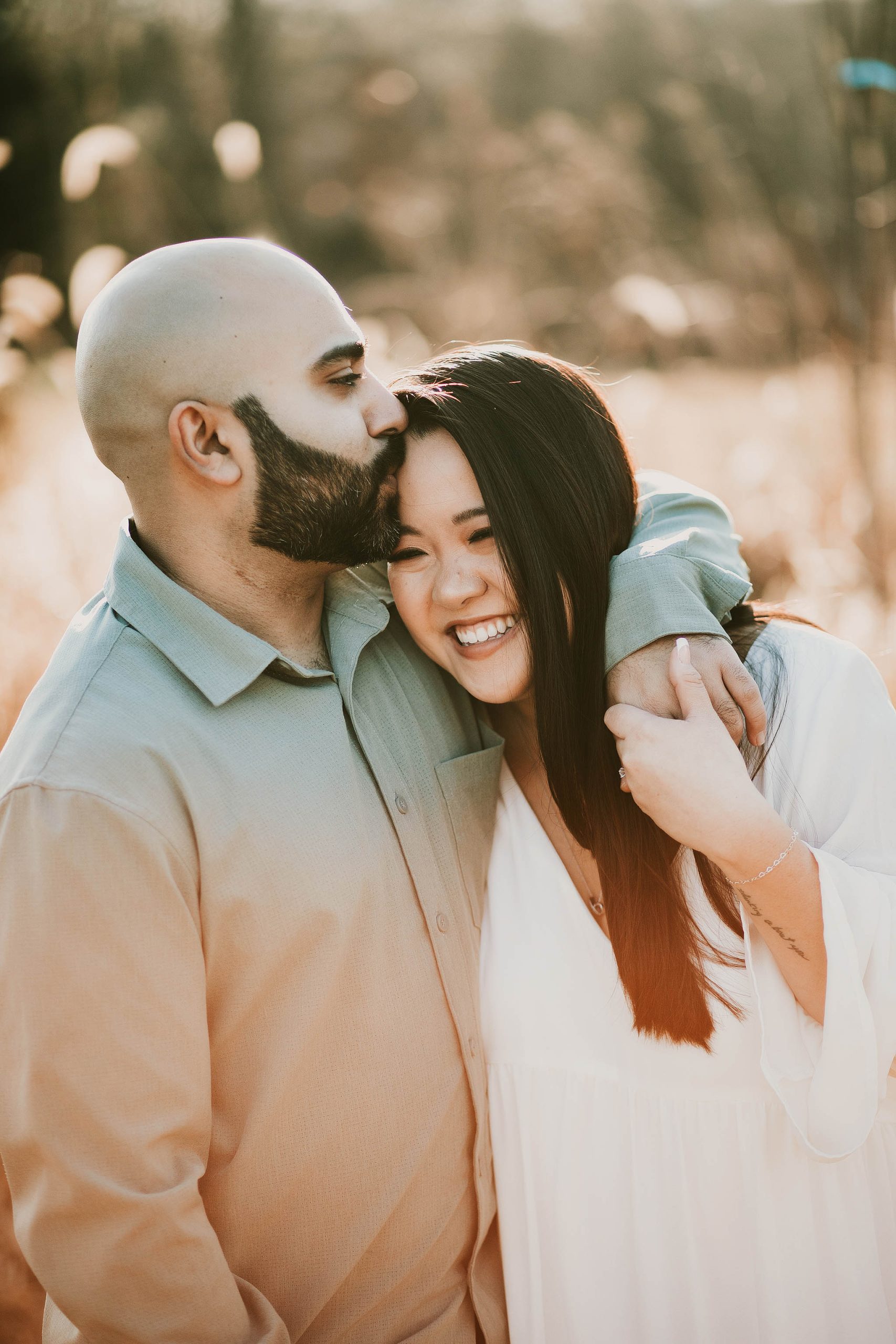 man kissing girl on head