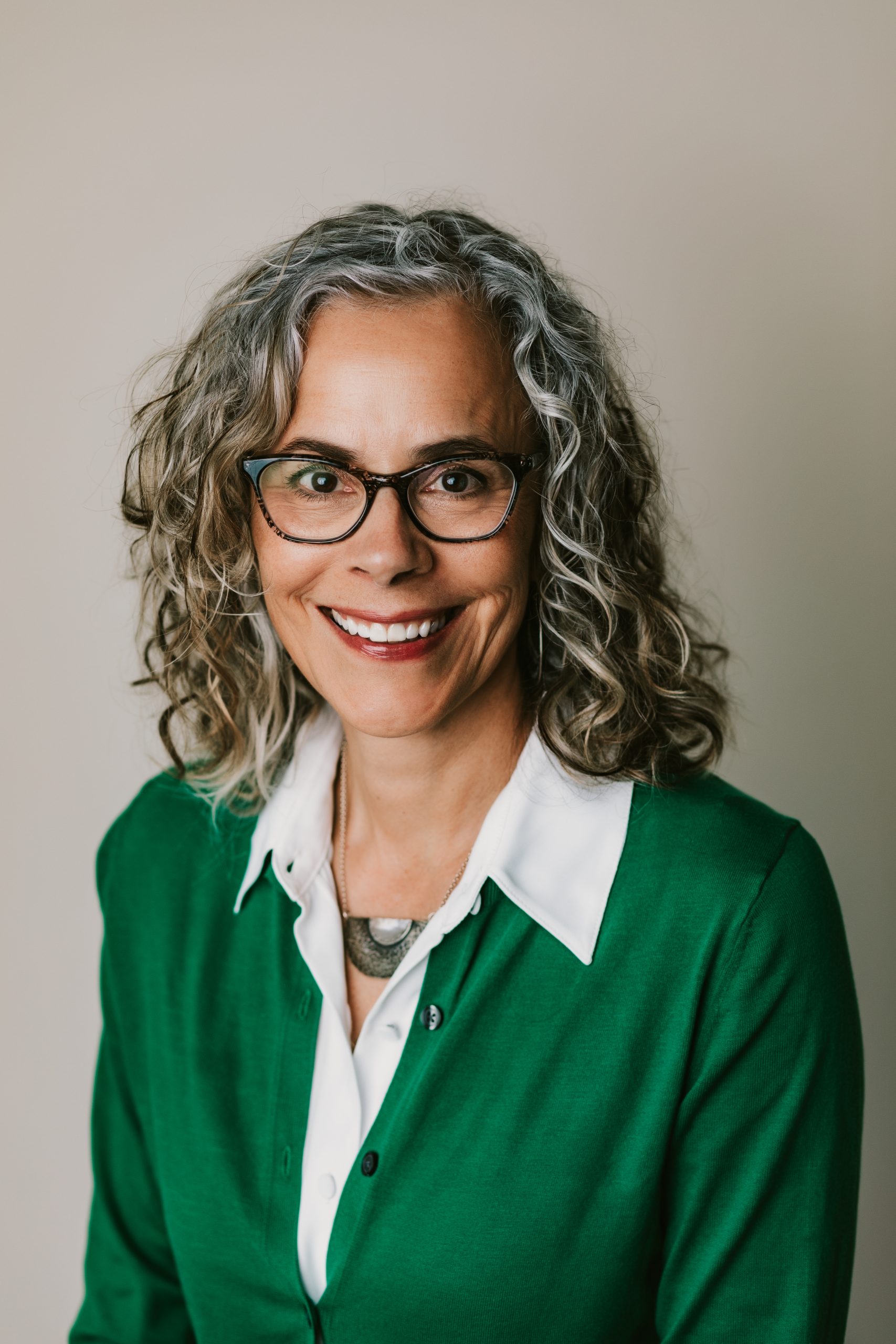 pretty woman in green jacket with glasses