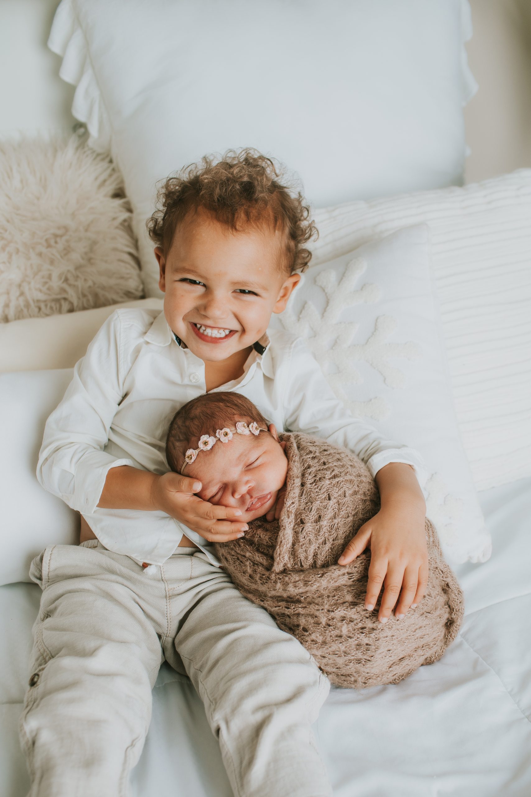 toddler holding baby sister