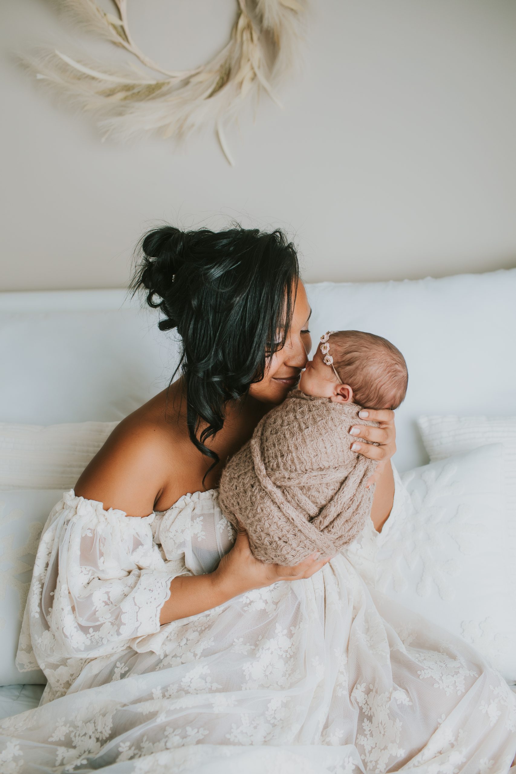 mother snuggling newborn girl
