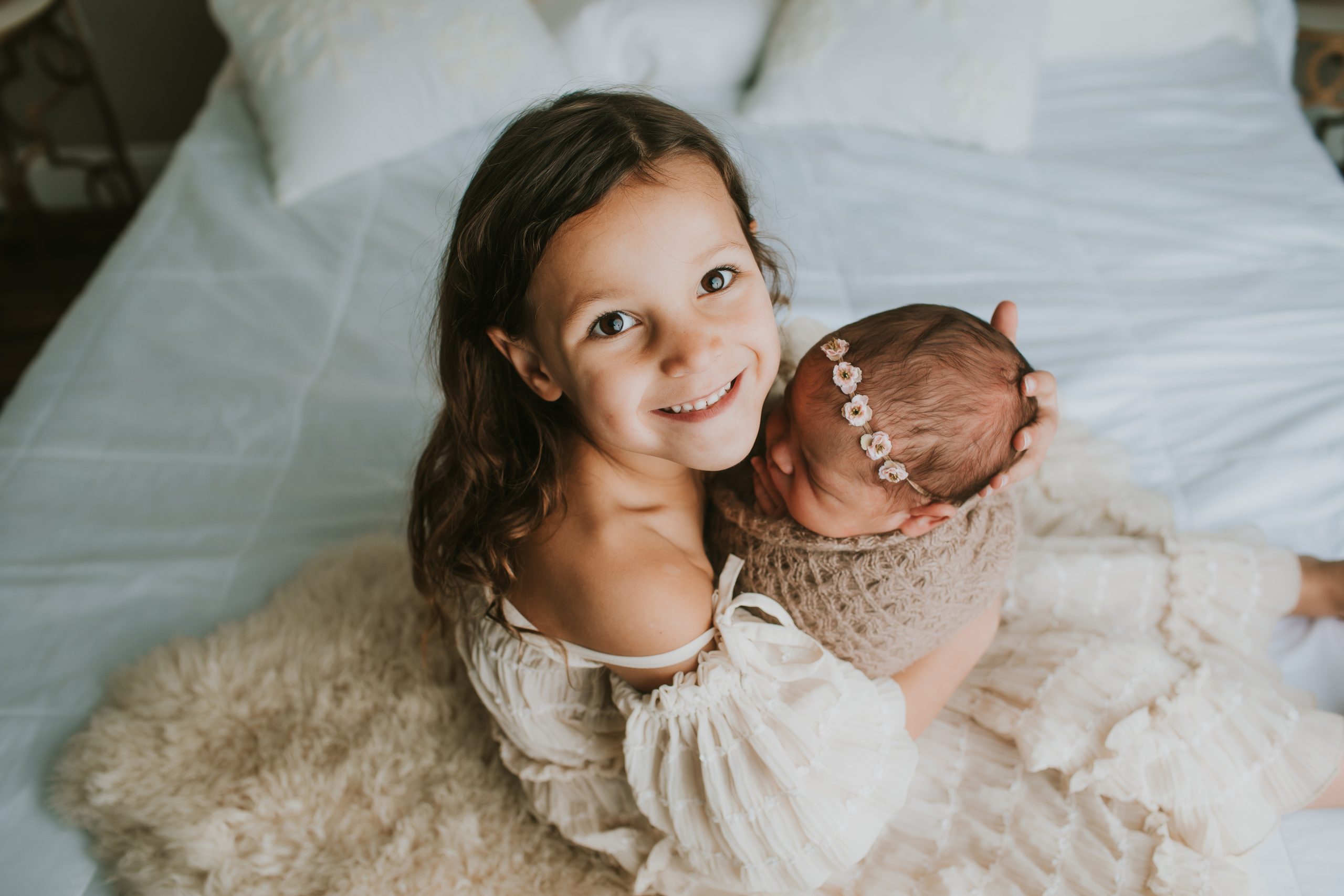 big sister holding newborn sister