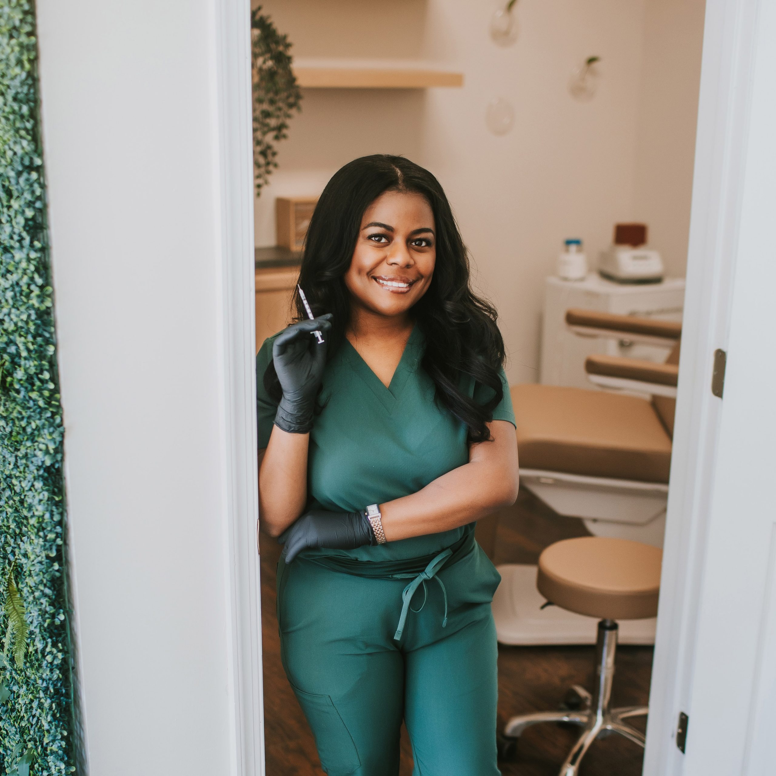 injector at medspa holding needle and smiling