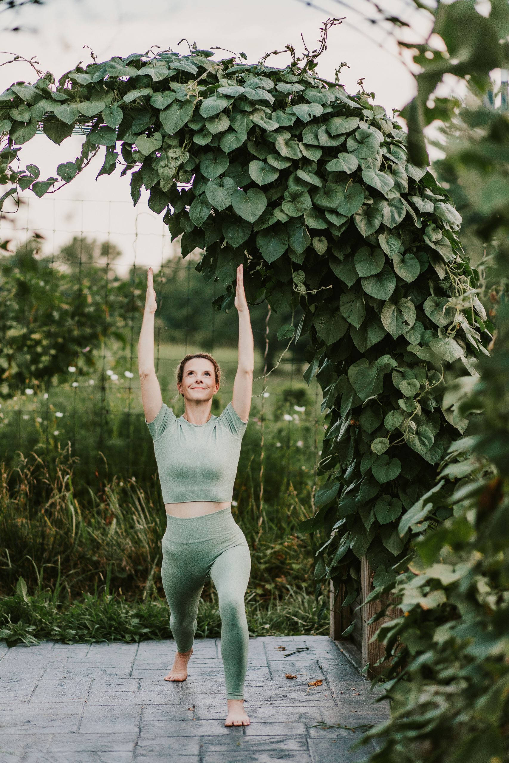 woman doing sun salutation in garden