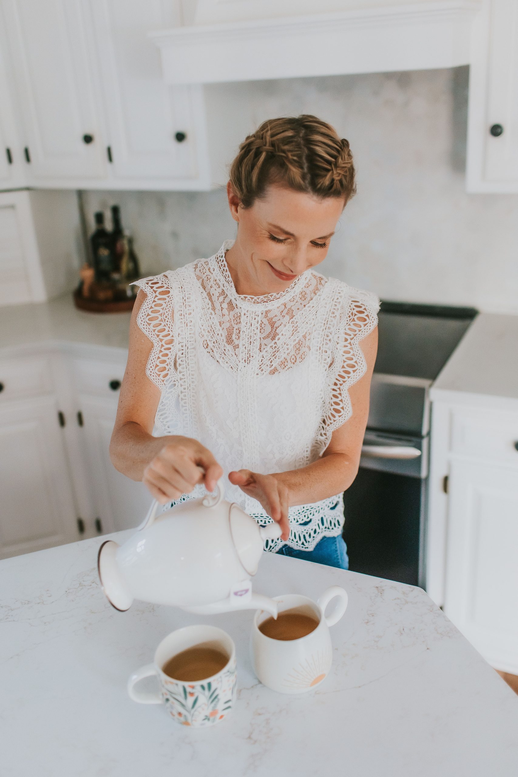 woman in white kitchen pouring tea