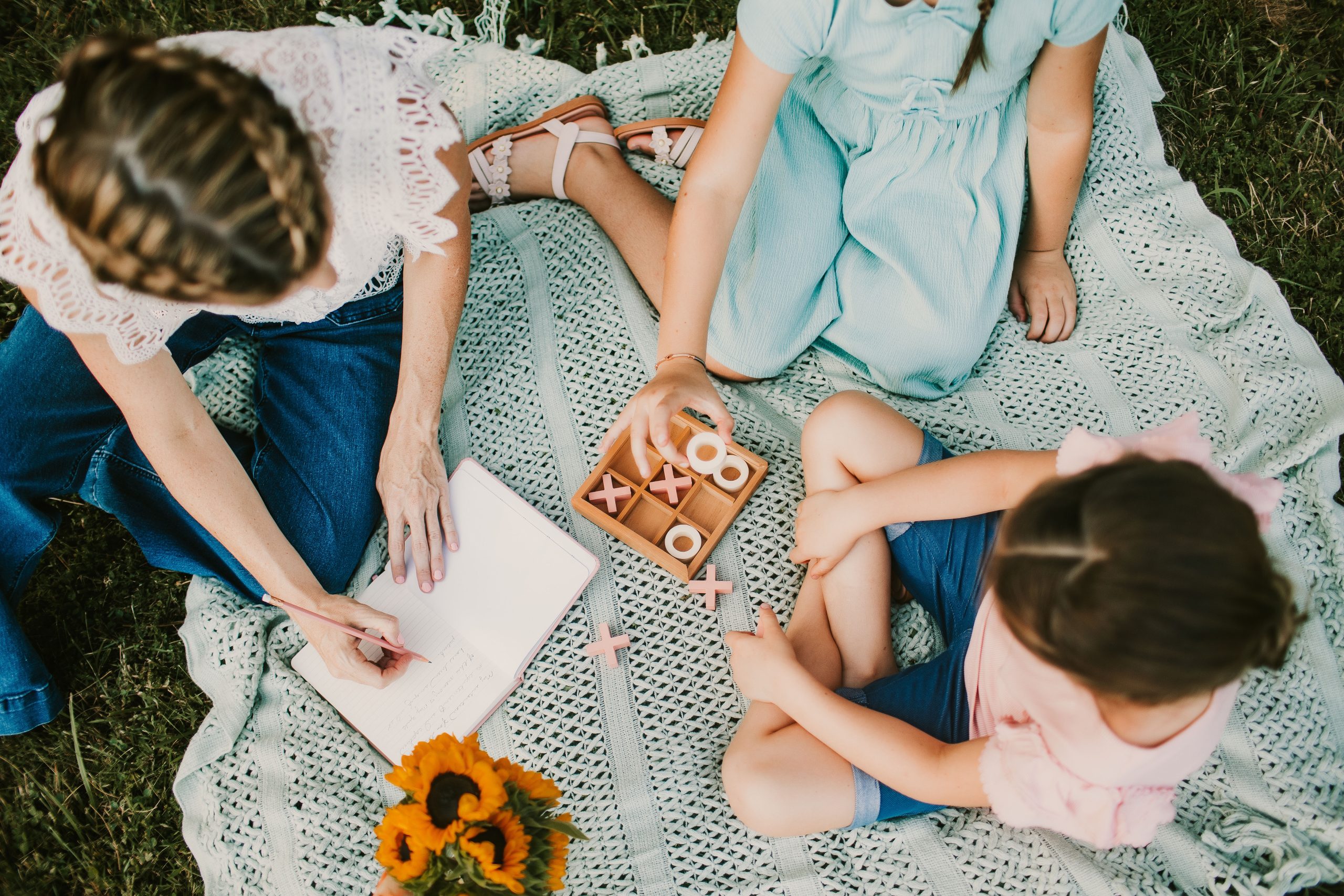 mom and daughters journaling outdoors