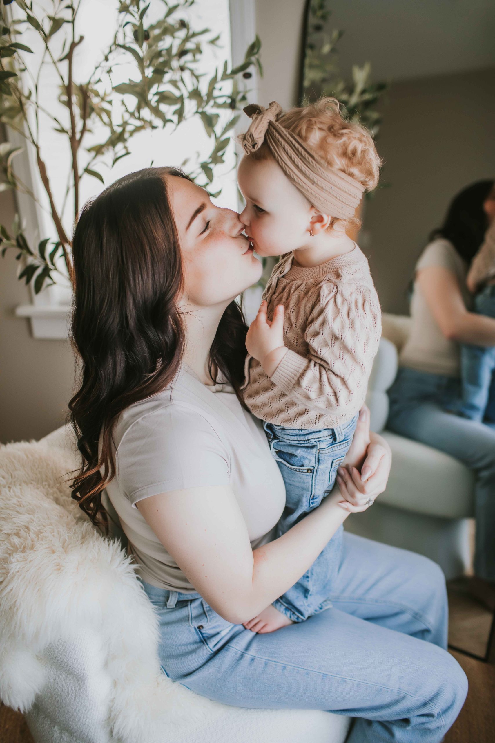 mother kissing toddler daughter