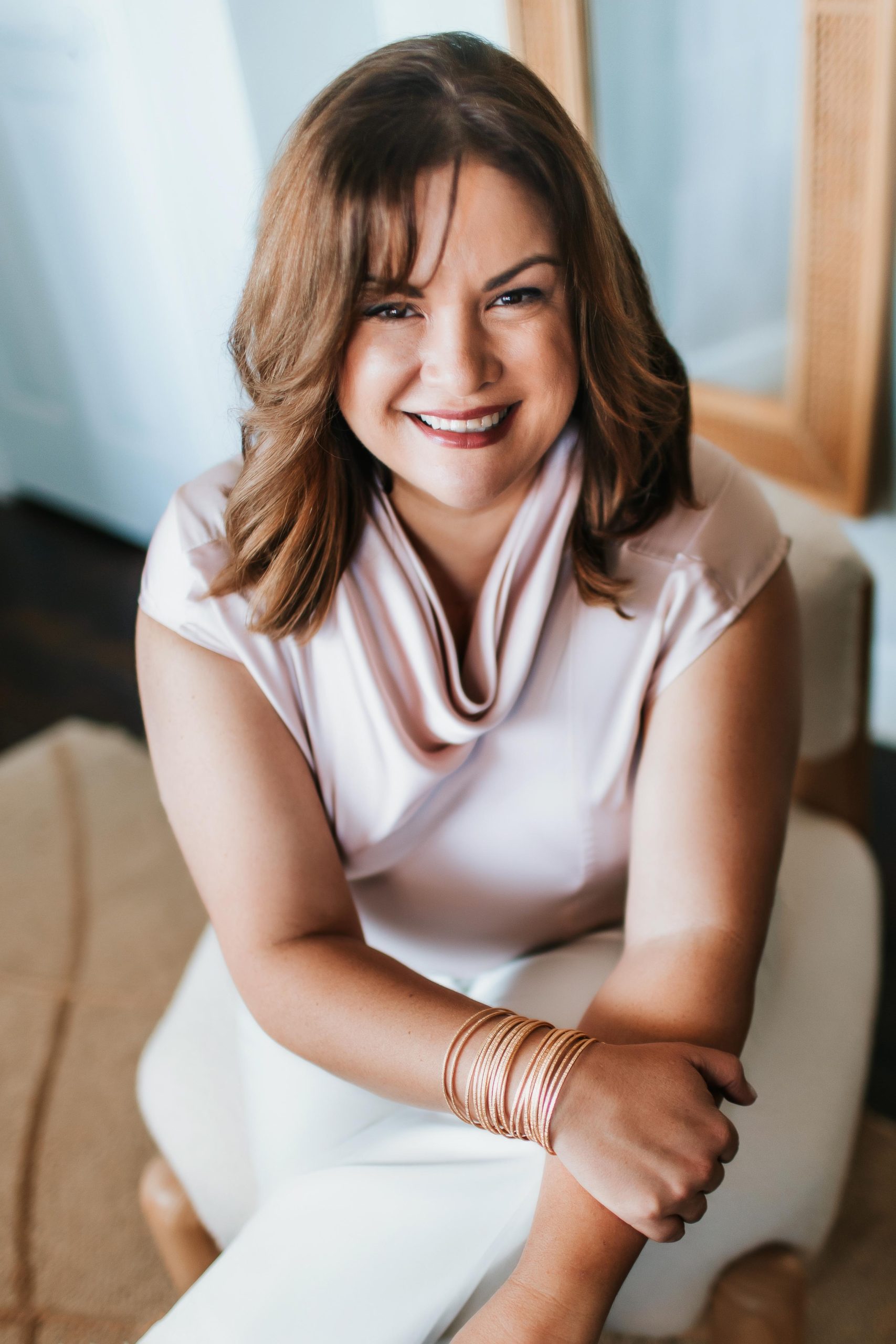 headshot of beautiful woman seated and laughing