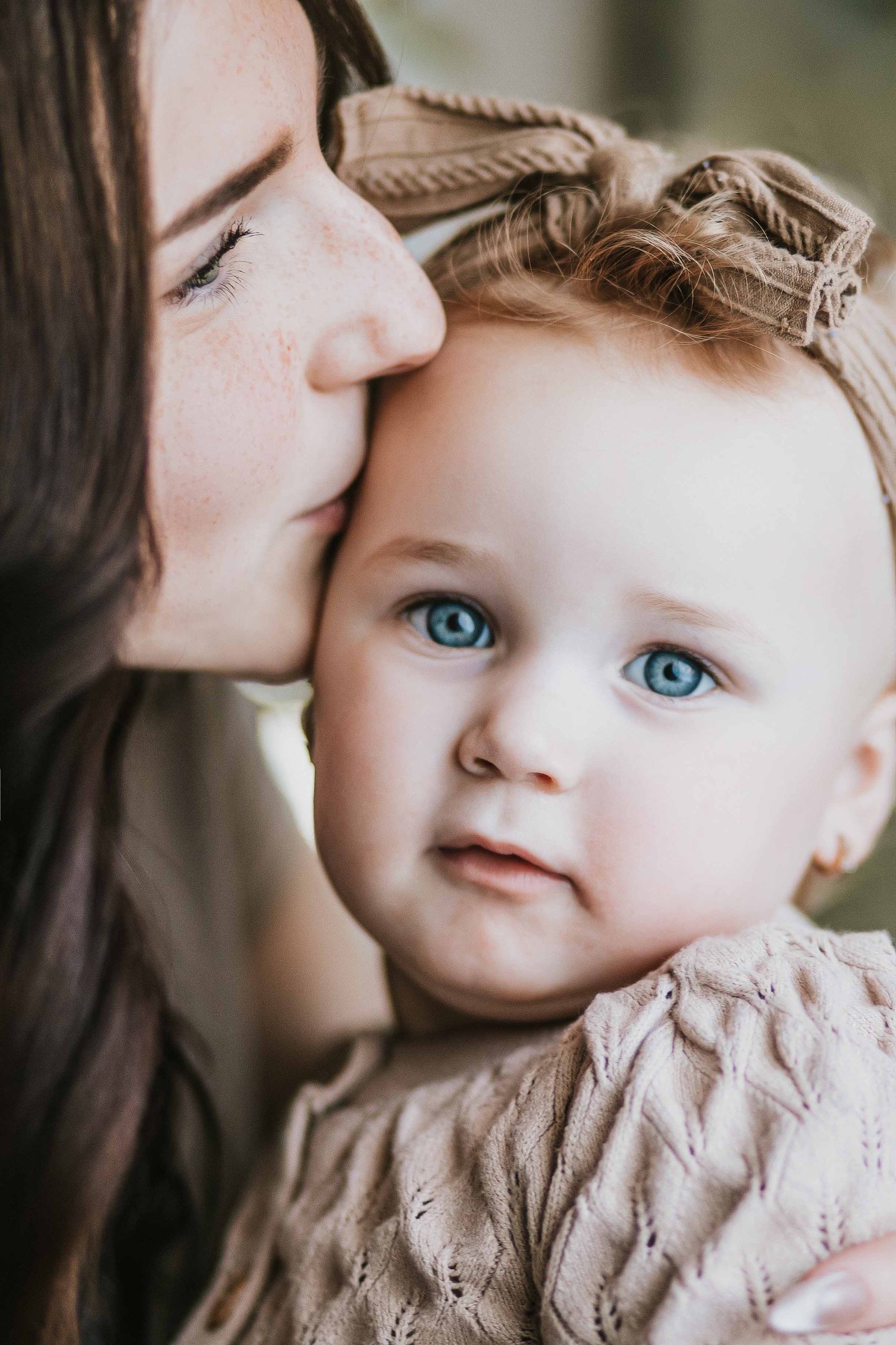 mom kissing toddler on forhead