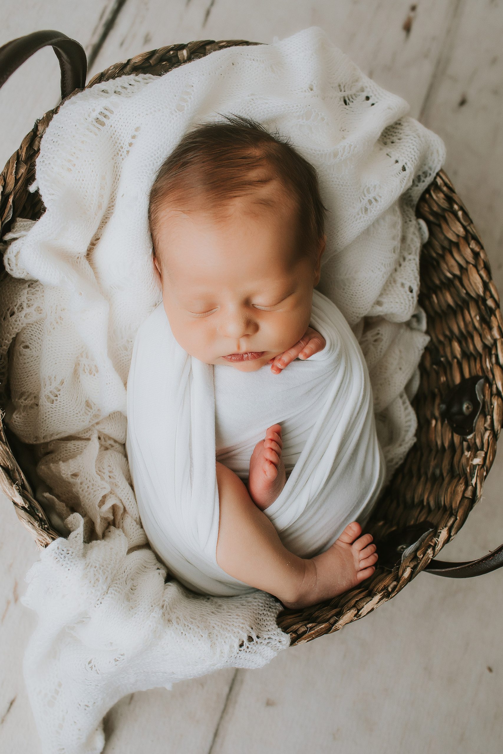 newborn boy in white swaddle