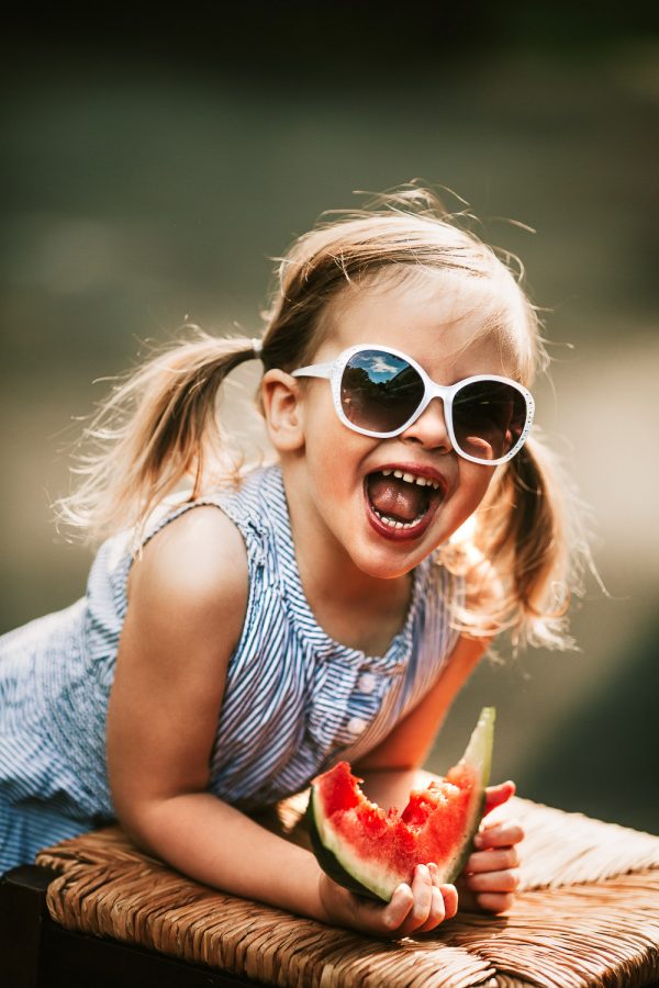 toddler in sunglsses with watermelon