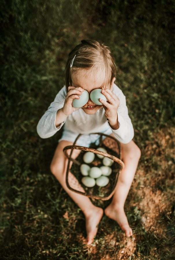 little girl holding blue eggs