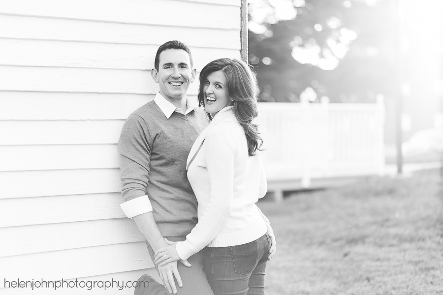 Engagement couple leaning against wall