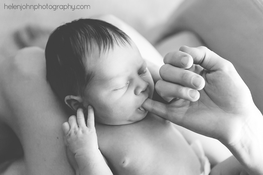 Baby sucking on parent's finger