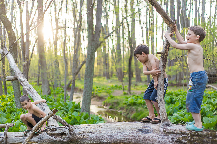 boy crossing fallen tree