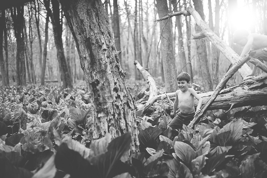 young boy laughing in woods