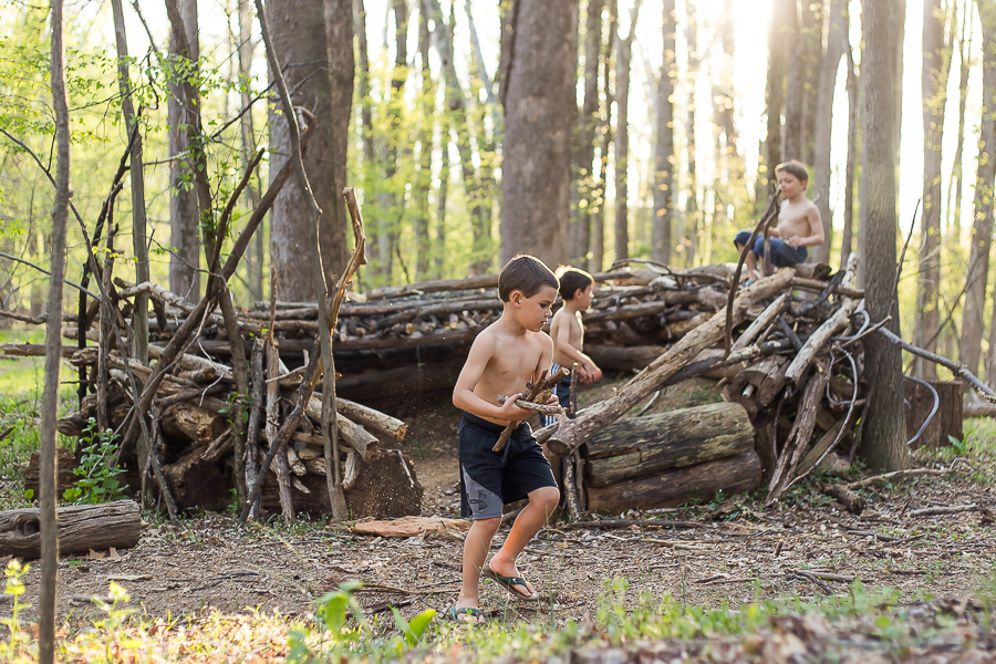 boy collecting sticks for fort