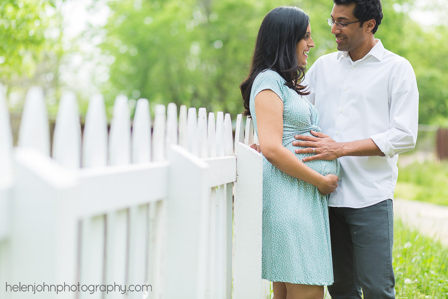 Expecting parents standing by a fence