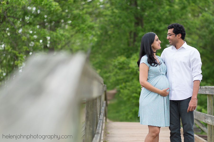 Soon-to-be parents standing on a bridge