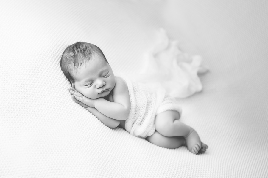 newborn boy sleeping with white mohair blanket B&W