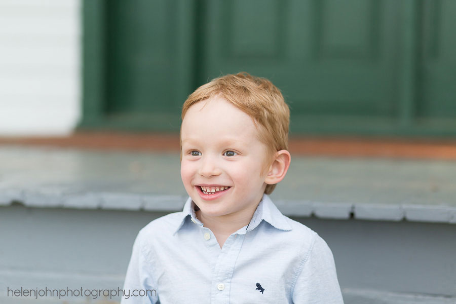 Little boy sitting on a porch smiling