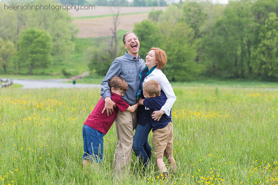 Family of four standing in a field laughing