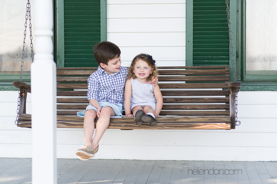 brother and sister sitting on porch swing together