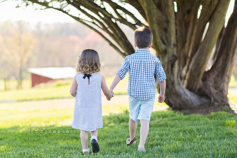 adorable brother and sister holding hands walking away