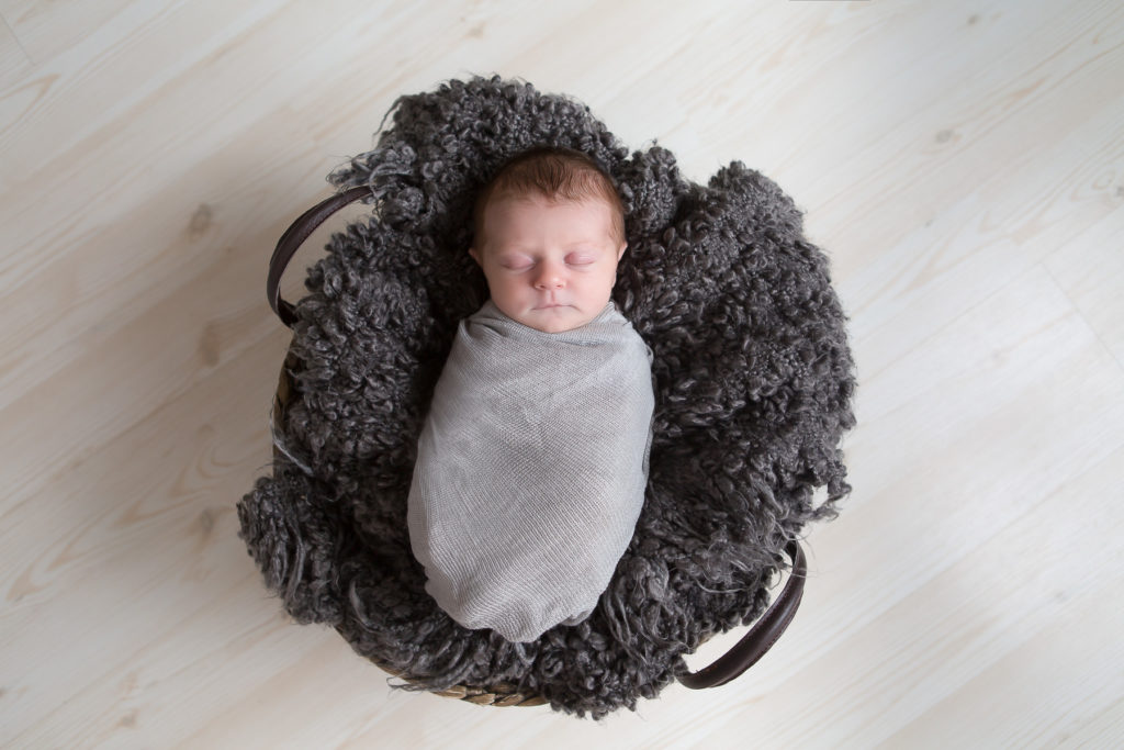 newborn baby asleep in basket