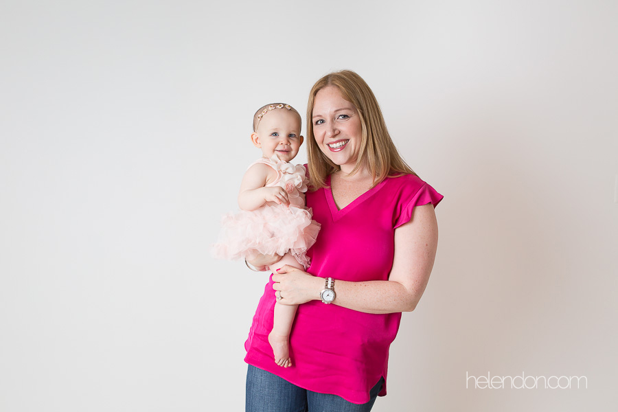 mom in pink shirt holding baby girl