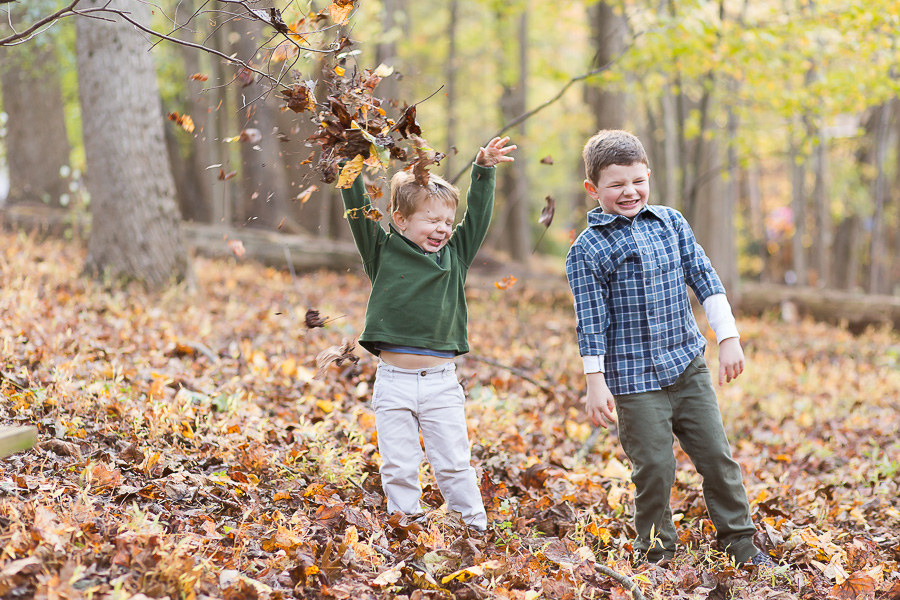 toddler throwing leaves with funny face