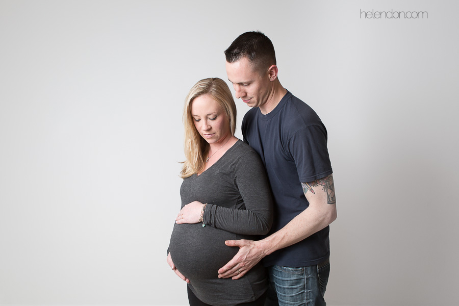 husband hugging pregnant wife studio shot