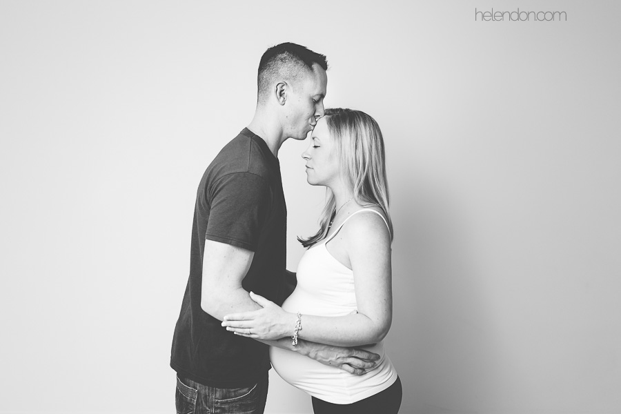 husband kissing pregnant wife's forehead