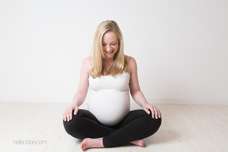 pregnant mom sitting cross legged laughing
