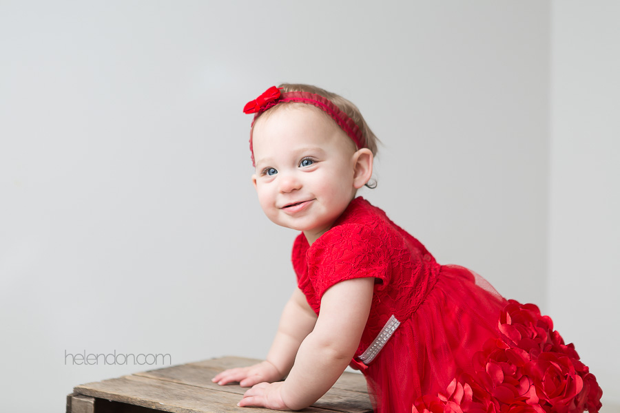 baby girl in red dress smiling