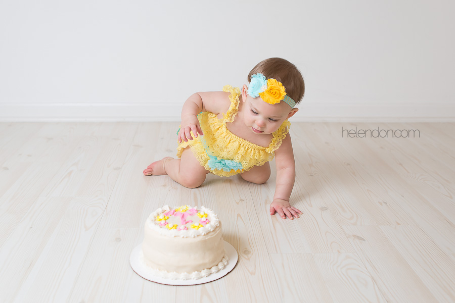 baby girl in yellow cake smash