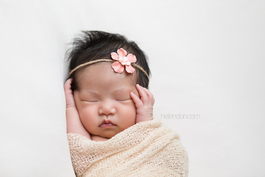 newborn girl holding her face