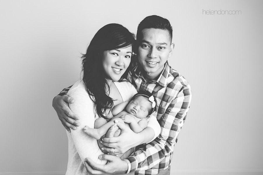 black and white image of parents holding newborn girl