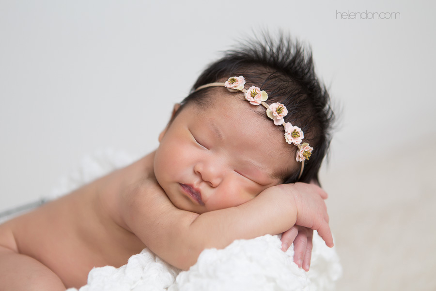 adorable newborn girl with lots of hair sleeping