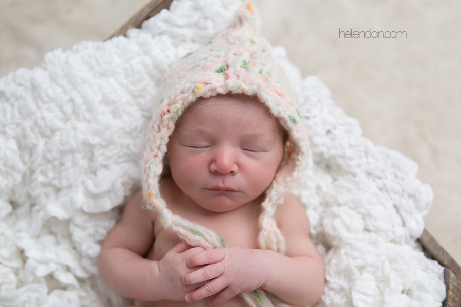 newborn in bonnet sleeping